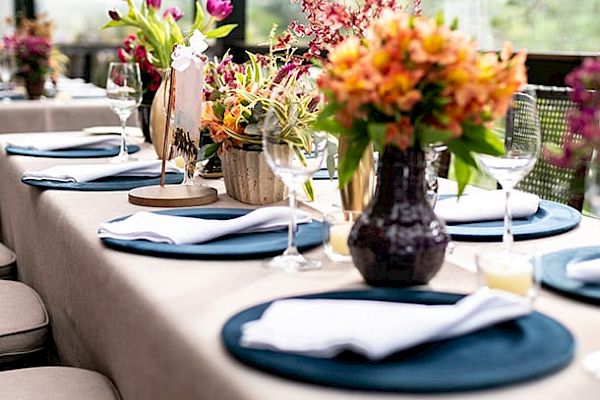 A beautifully set table with flowers, napkins, plates, and wine glasses in an elegant and colorful arrangement.