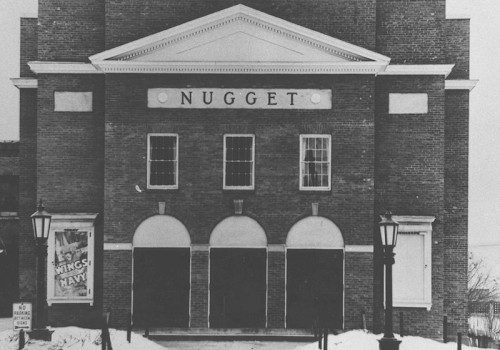 A vintage photo of the Nugget Theater building in winter, with a classic brick facade and snow-covered ground.