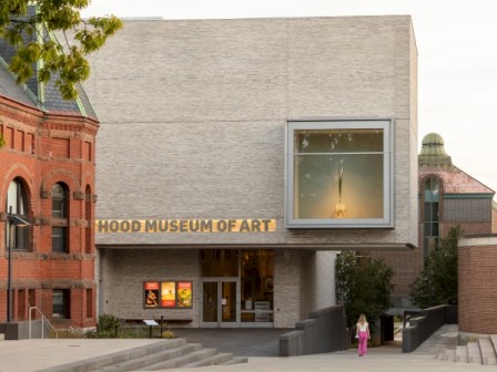 This image shows the entrance of the Hood Museum of Art with large windows and a modern exterior design.