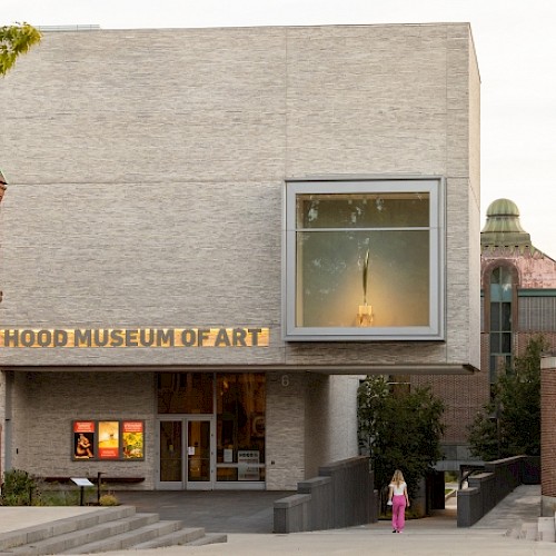 The image shows the entrance of the Hood Museum of Art, featuring contemporary architecture and a display window.