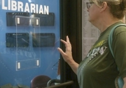A person stands in front of a glass door labeled 