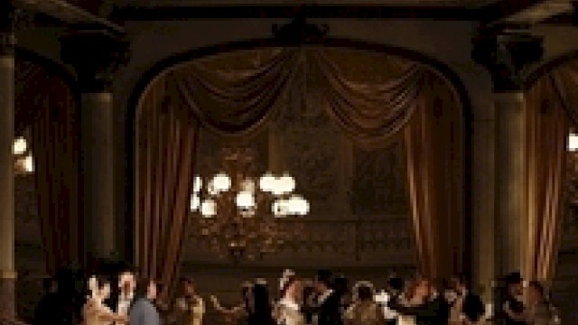 An elegant ballroom scene with people in 19th-century attire dancing under ornate chandeliers, surrounded by lavish drapery and decor.