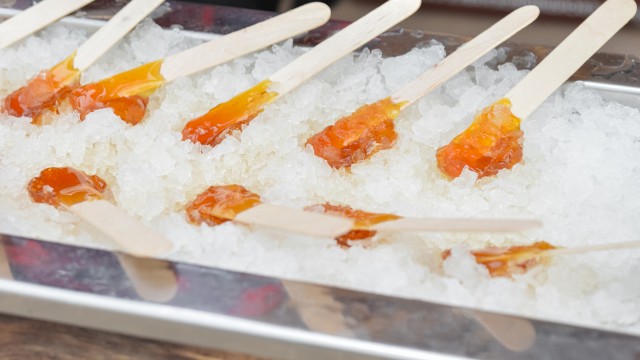 Colorful popsicles are cooling on ice in a tray.