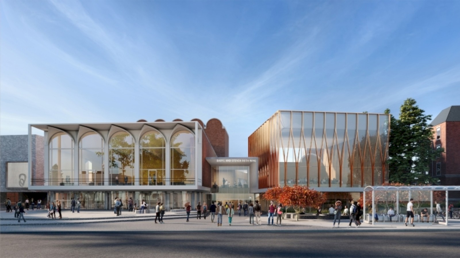 A modern architectural building with glass facades, surrounded by people, trees, and a bus stop, under a clear blue sky.