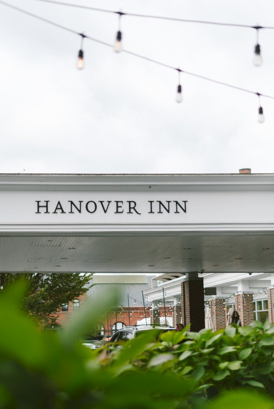 A sign for the Hanover Inn is visible beneath some string lights on a cloudy day.